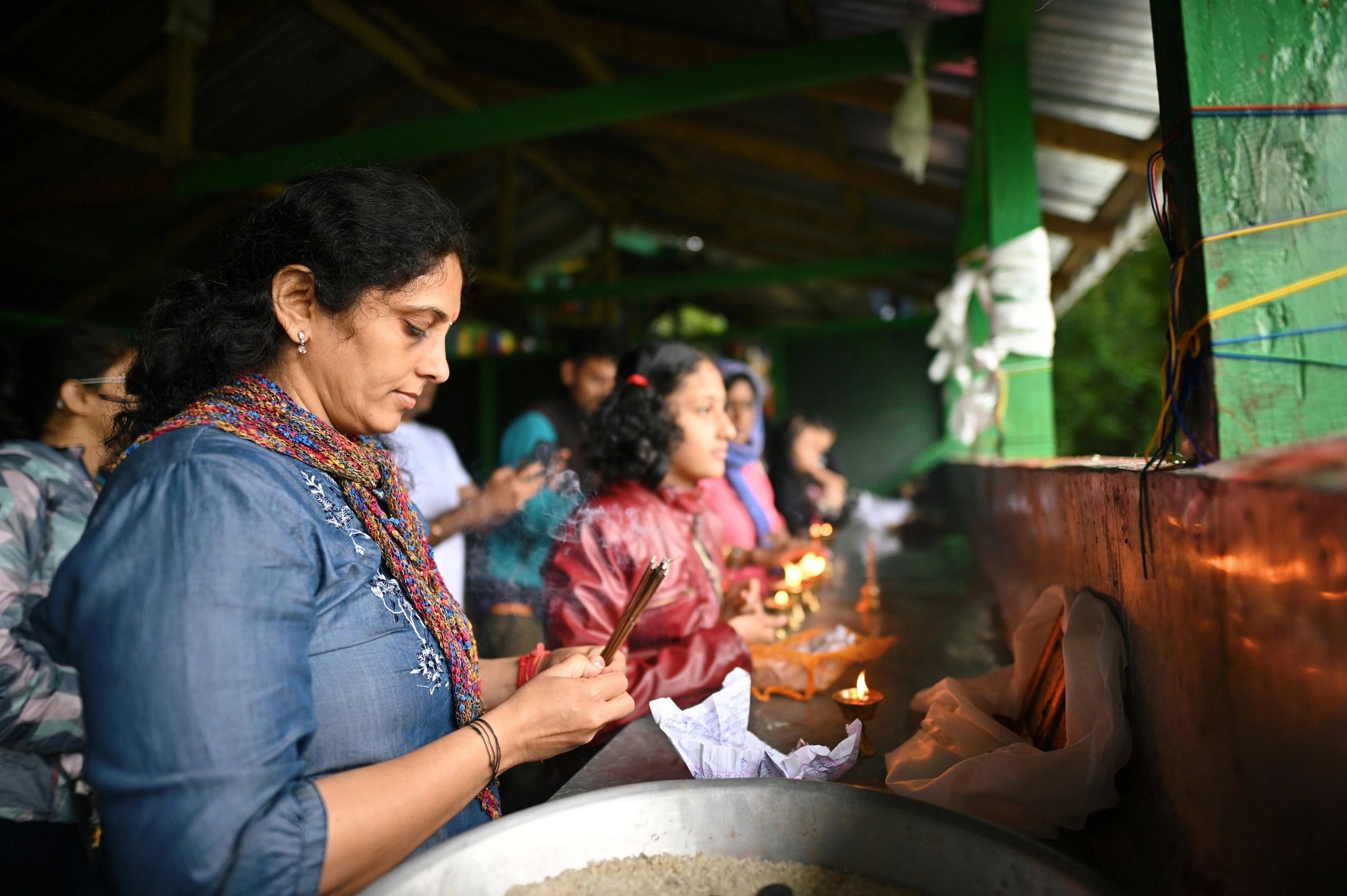 Woman praying with incense sticks in India